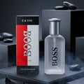 BOSS BOOSTYLE E & YOU perfume bottle and packaging box displayed on a dark gray pedestal with black stones in the background.